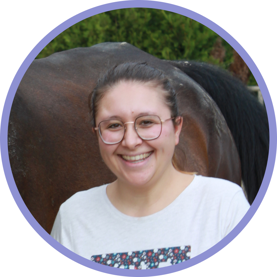 a woman wearing glasses standing in front of a horse